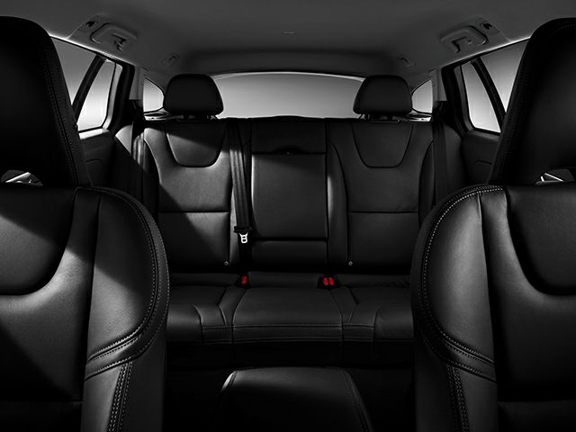 Black leather rear seats with headrests and stitching in a car interior.