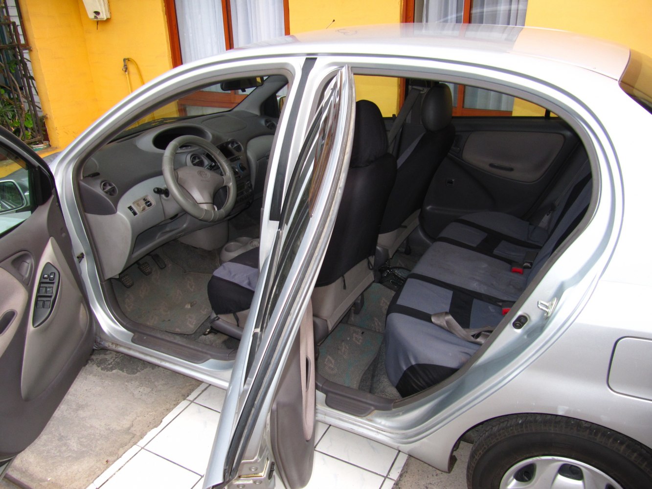 Interior view with open front and rear doors, dashboard, and seats
