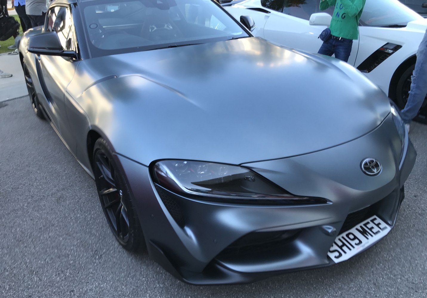 Sleek matte gray sports car front with aggressive headlights