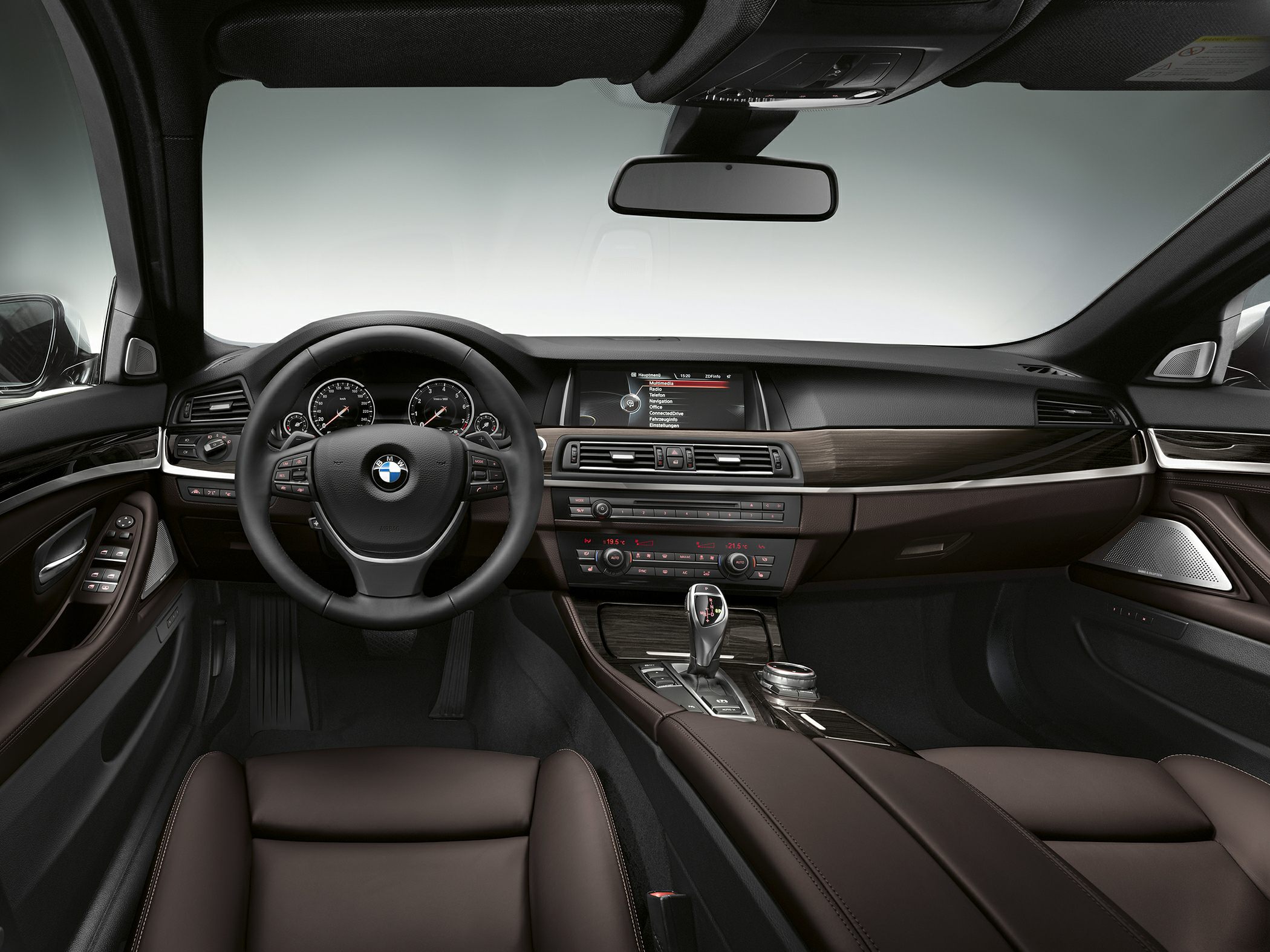 Dashboard, steering wheel, infotainment, and gear selector in brown leather interior