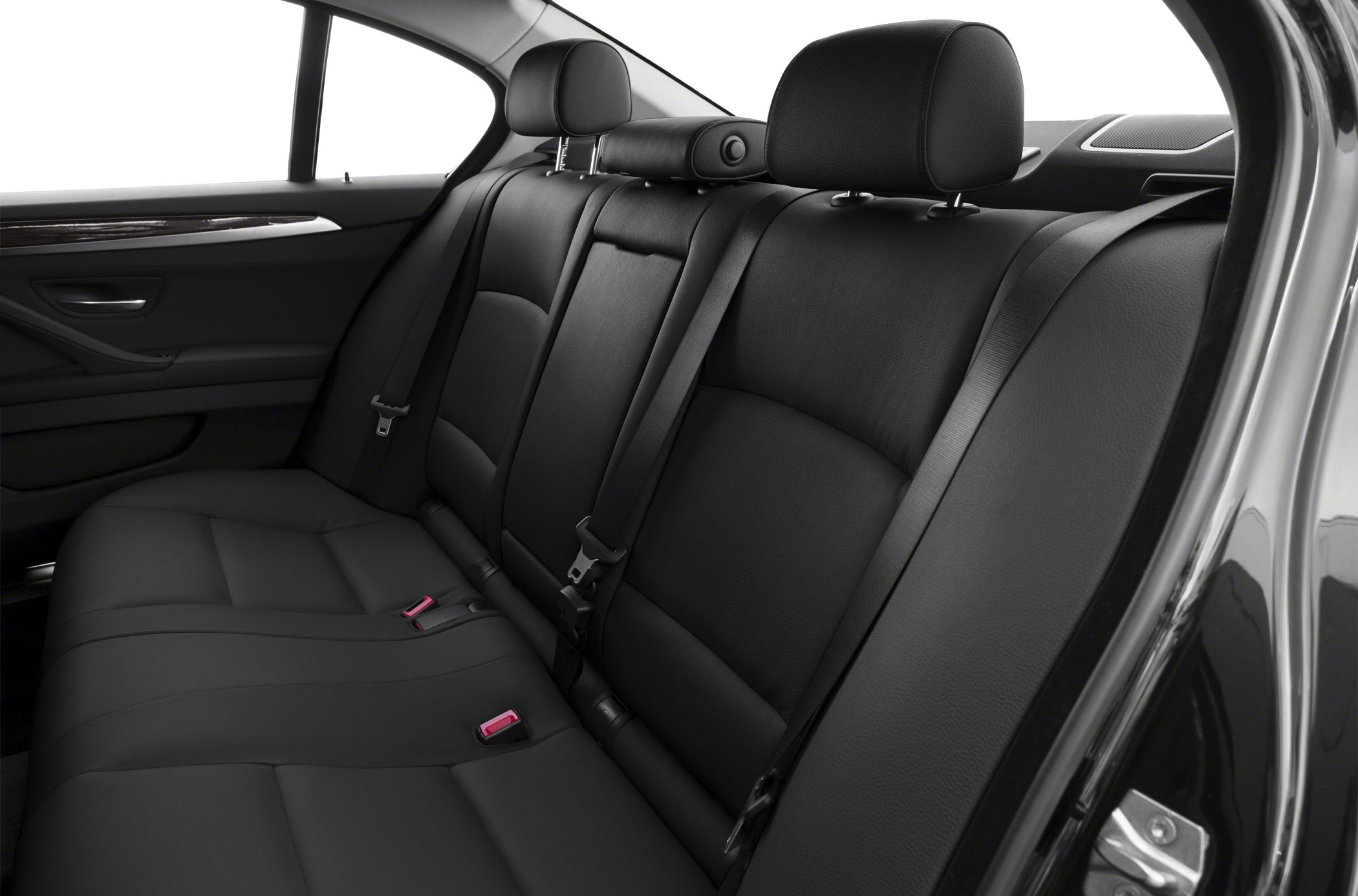 Black leather rear seat with seat belts and headrests.