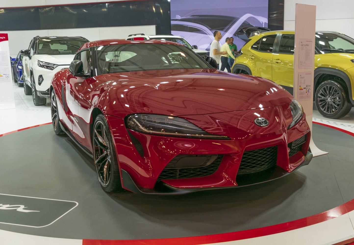 Glossy red sporty coupe with sharp headlights and aerodynamic front grille