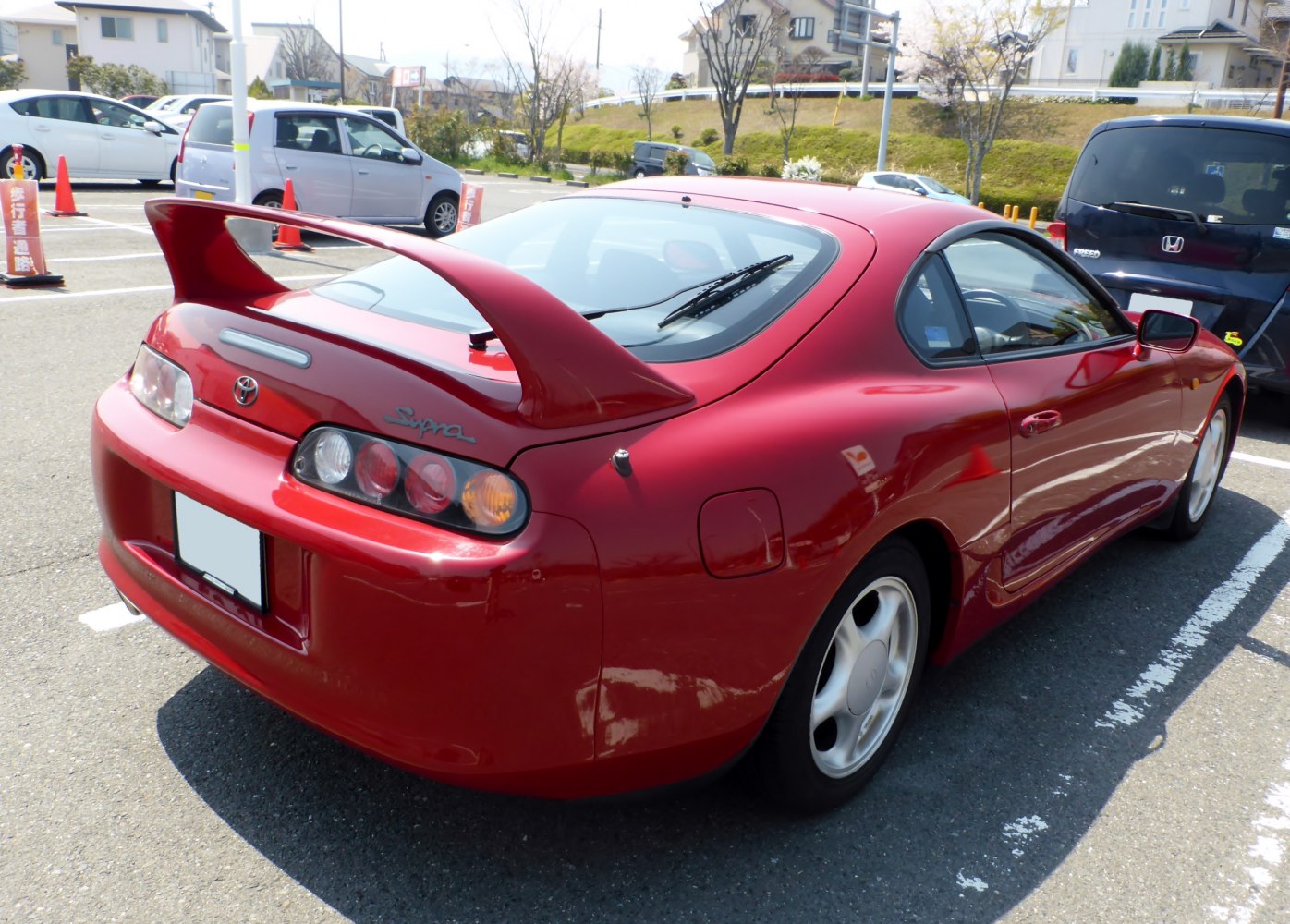 Rear and side view of red sports coupe with large spoiler and aerodynamic shape