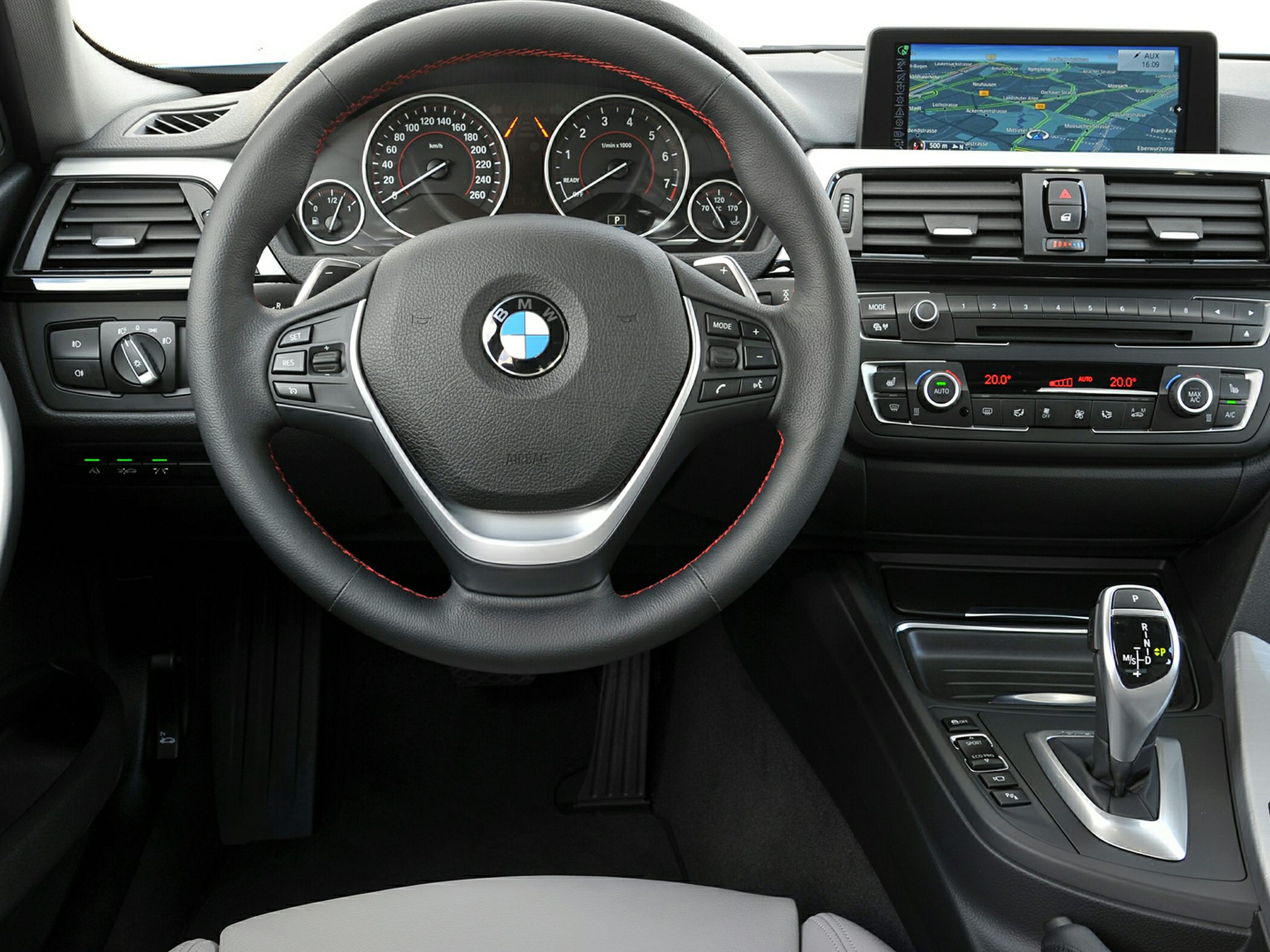 Steering wheel, dashboard gauges, infotainment screen, and gear shifter