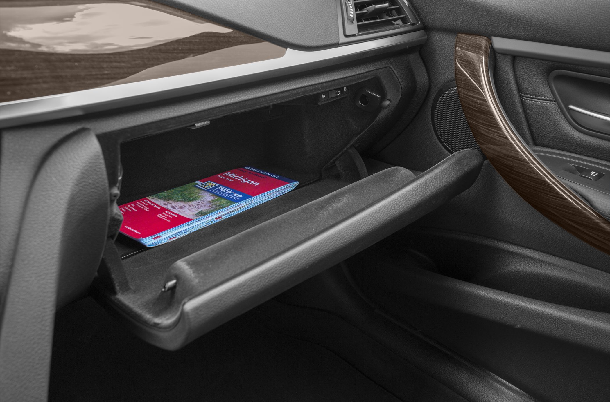 Open glove compartment and wood trim door handle in car interior