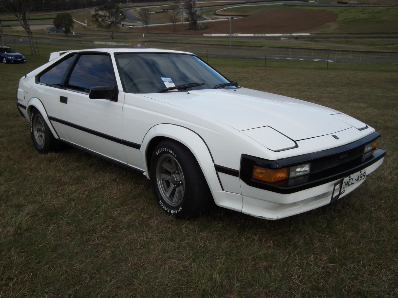 White retro sports coupe with pop-up headlights and angular design