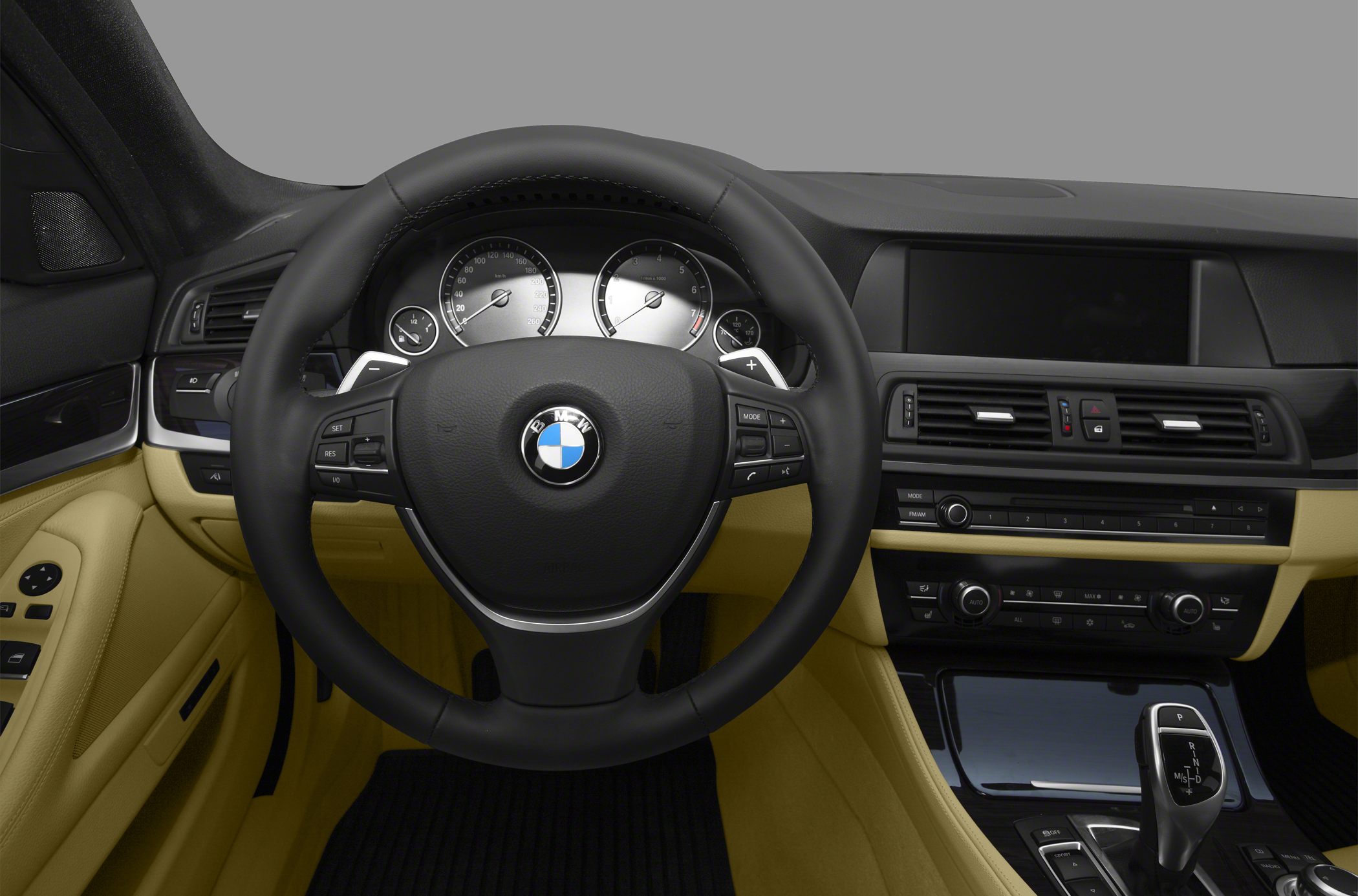 Steering wheel and dashboard with gear shifter inside a luxury car interior
