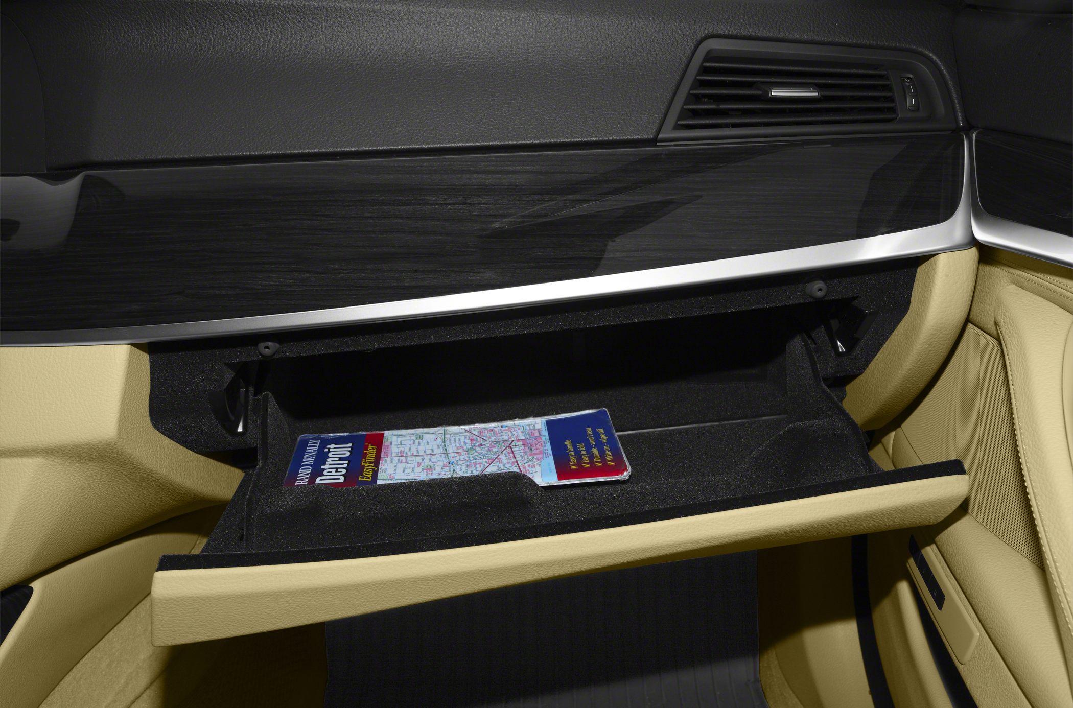 Glove box interior with beige lining and black dashboard trim