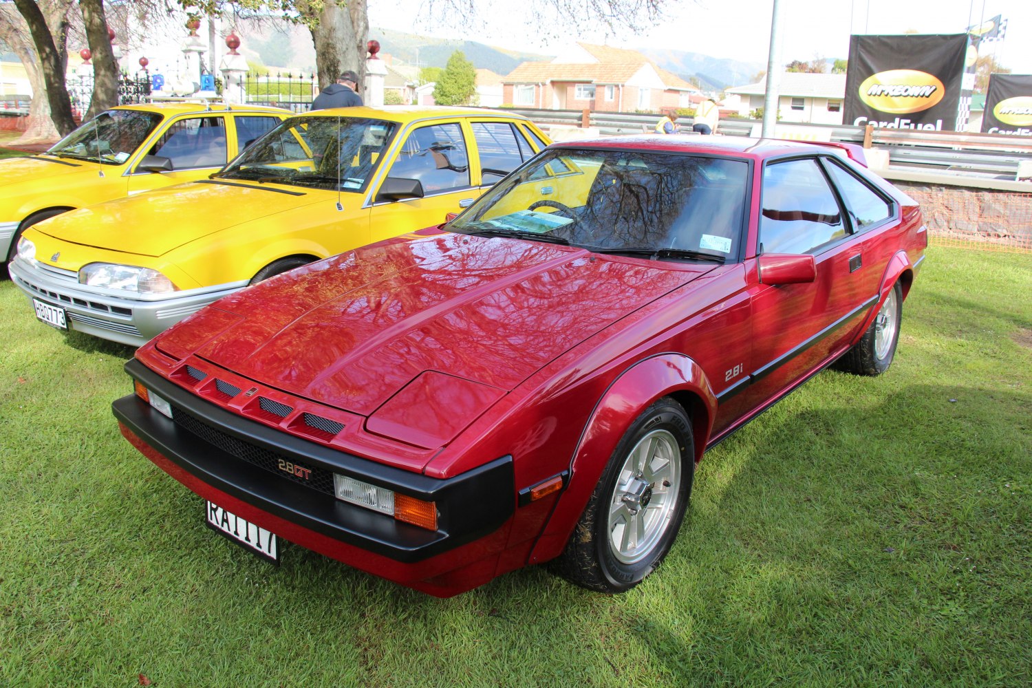 Red 1980s sports coupe with pop-up headlights and wide fenders