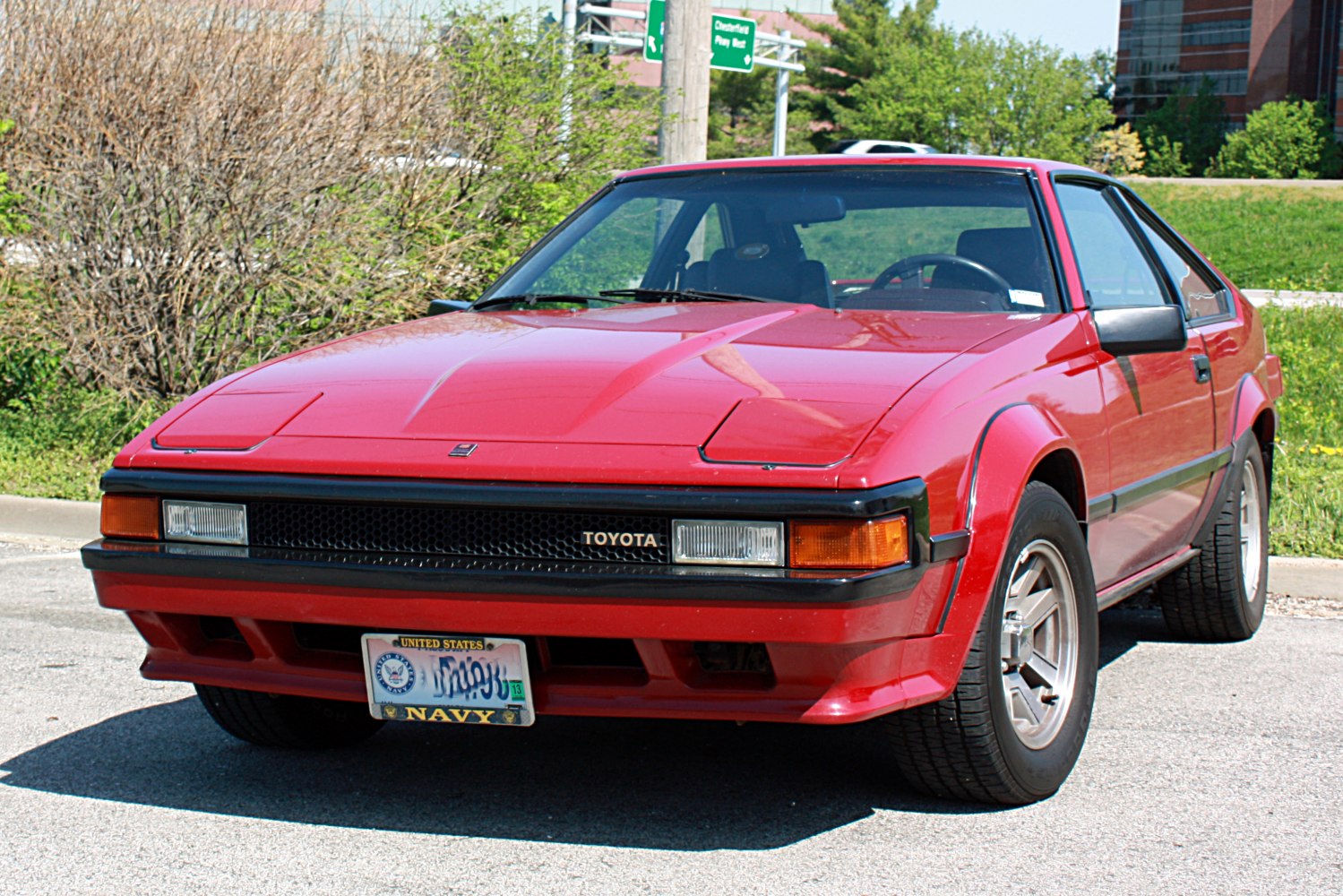 Red sports coupe with pop-up headlights and alloy wheels.