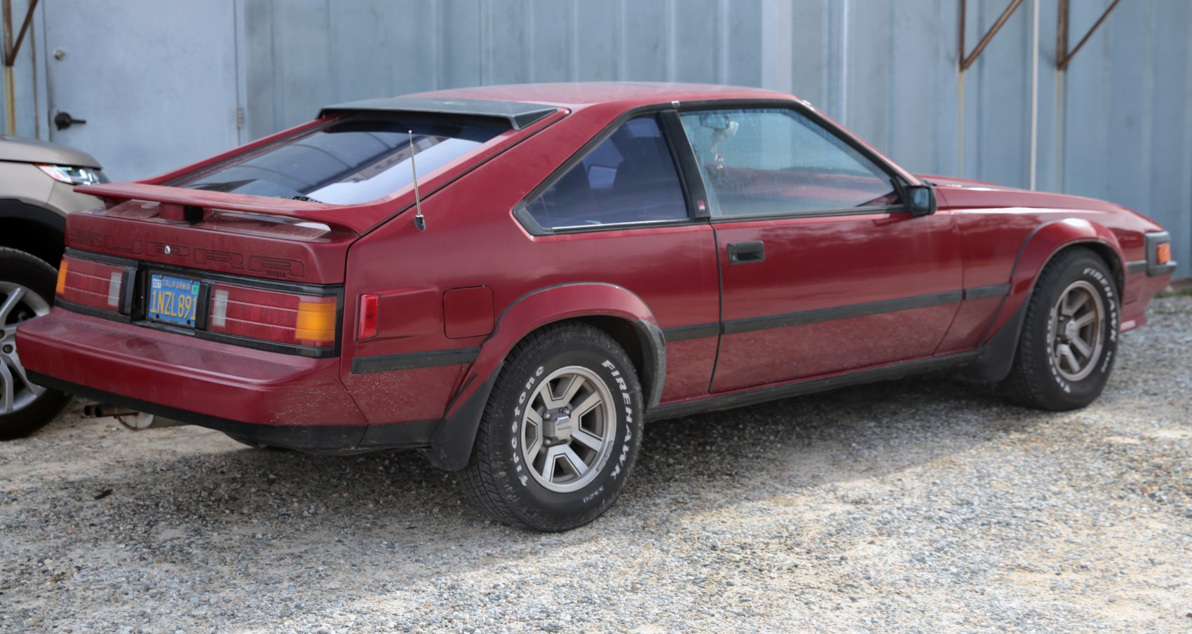 Rear-side profile of vintage sports coupe with spoiler