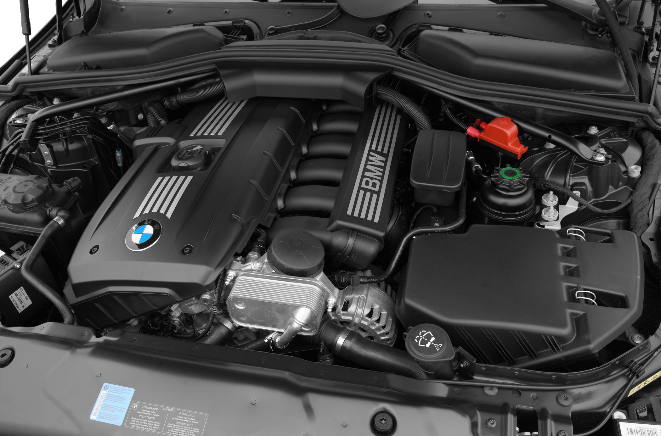 Inline-six engine bay with BMW branding, detailed engine components.