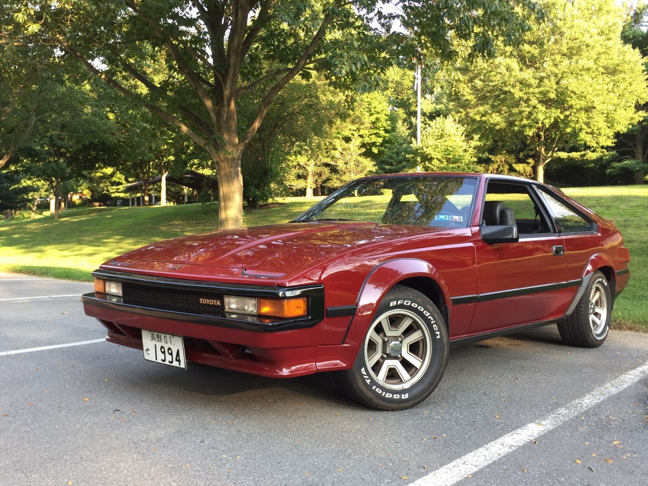 Red vintage sports coupe with pop-up headlights and distinctive angular design.