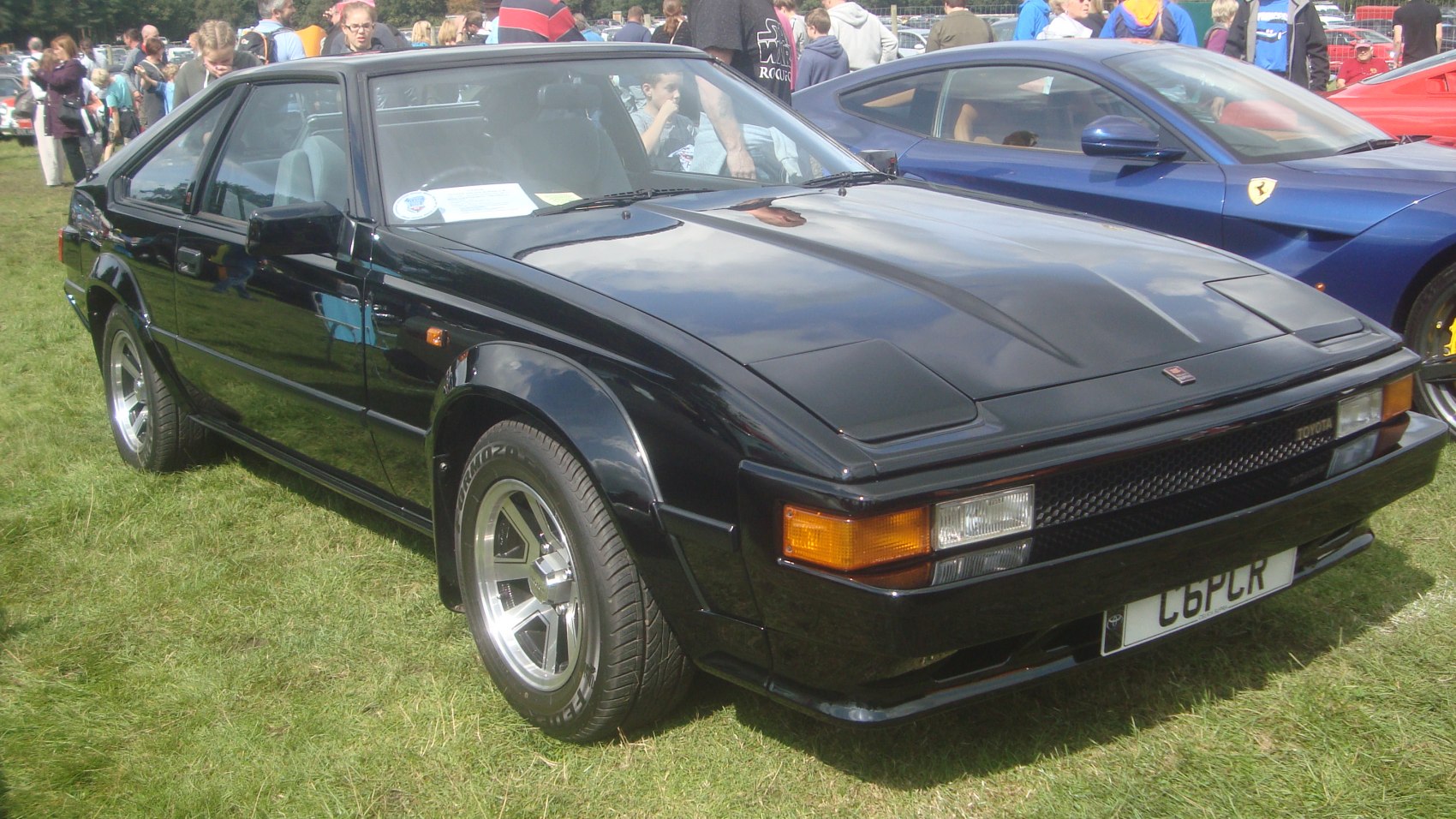 Black vintage sports coupe with pop-up headlights and angular design