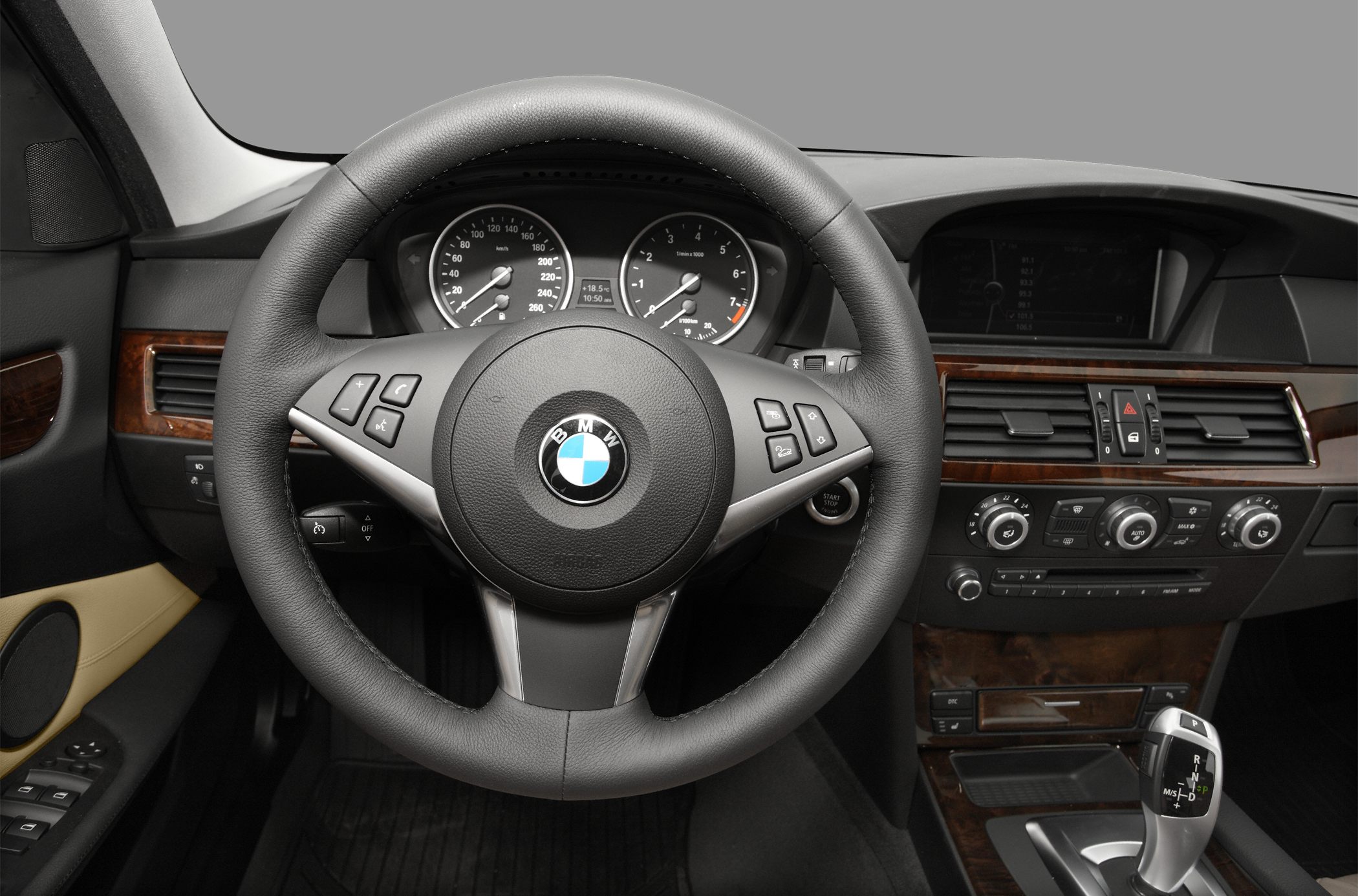 Steering wheel and dashboard with instrument cluster and center console wood trim