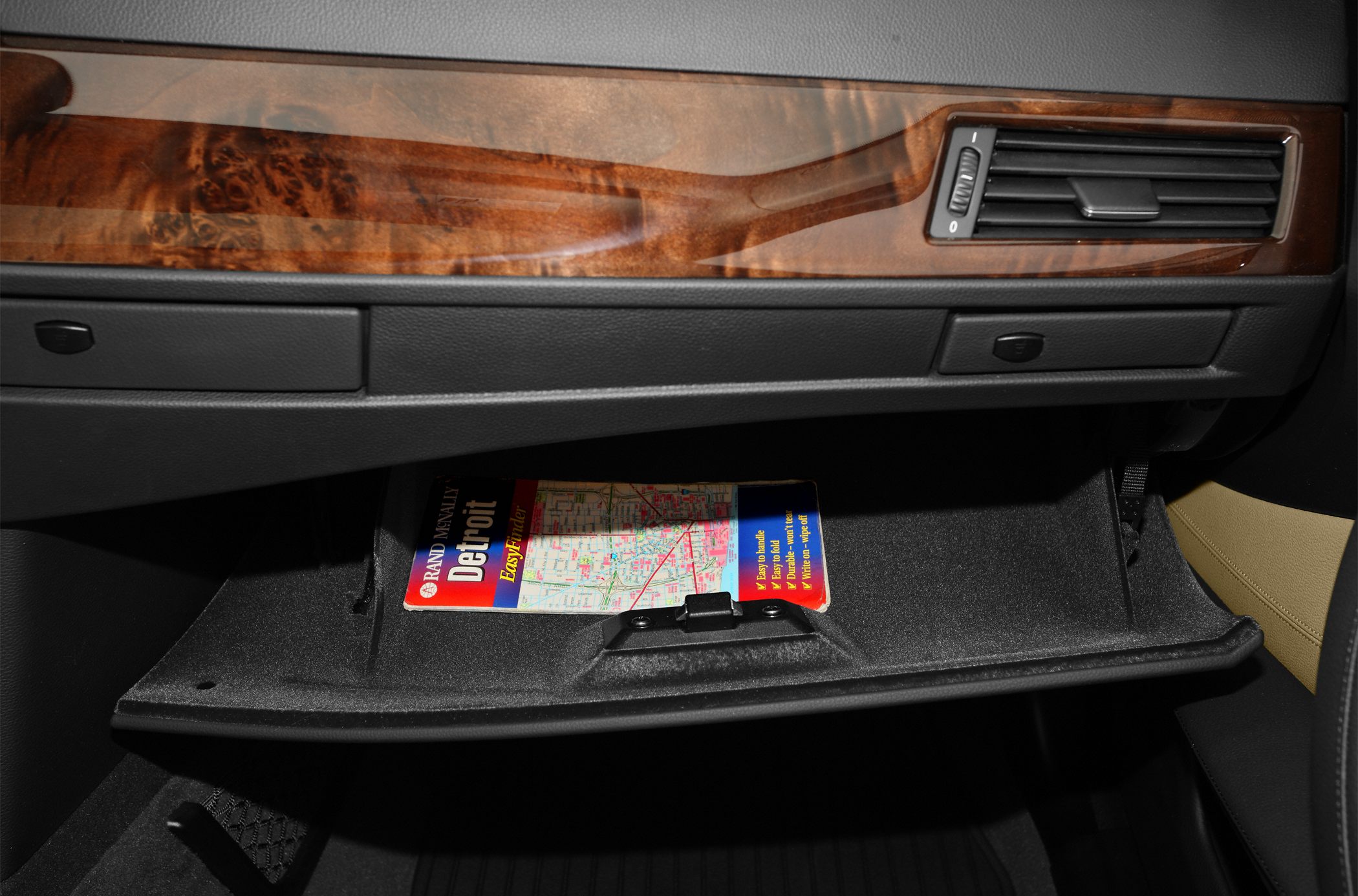 Open glove compartment with wood trim and air vent