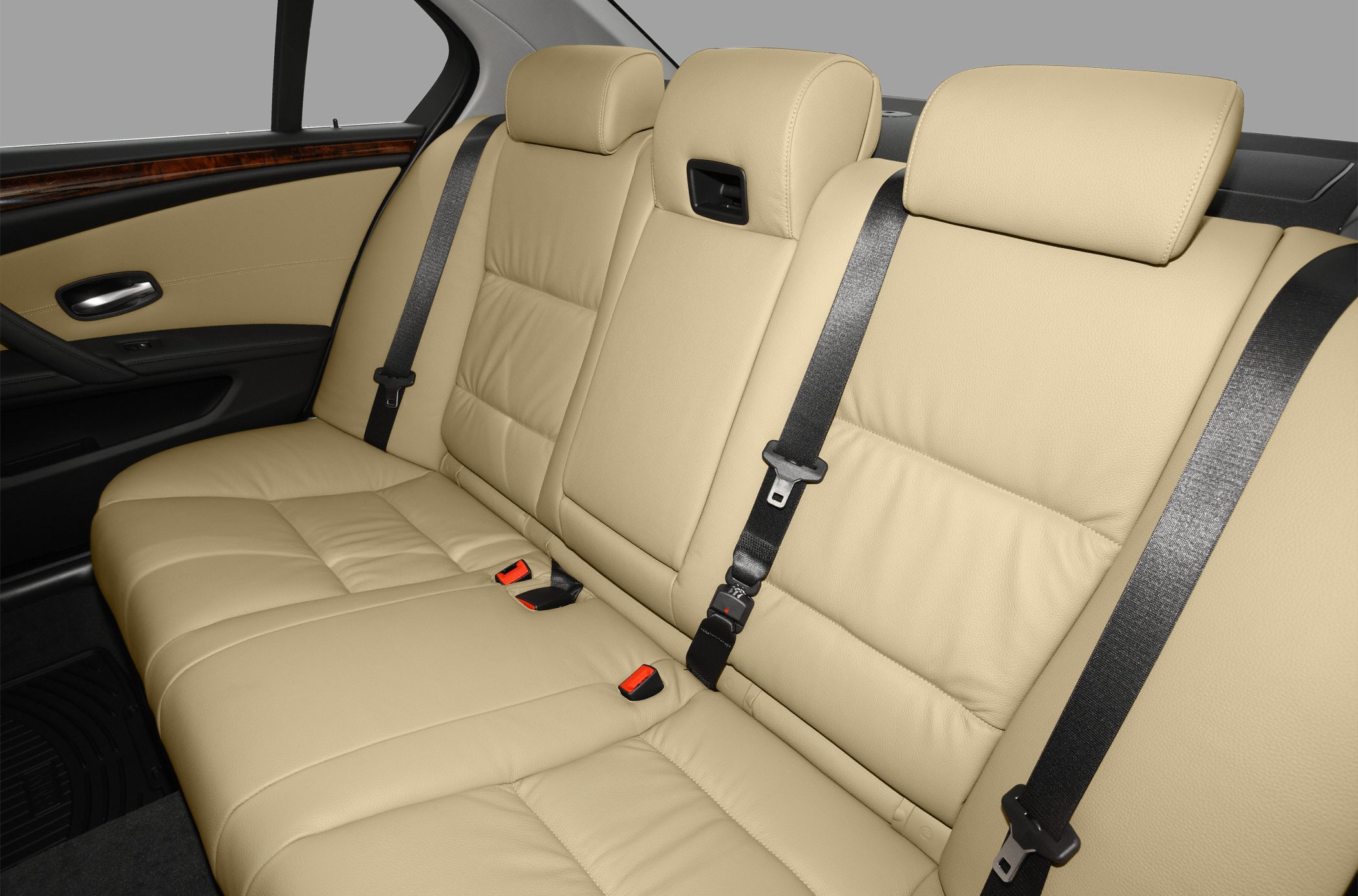 Beige leather rear seats with seat belts and wood trim