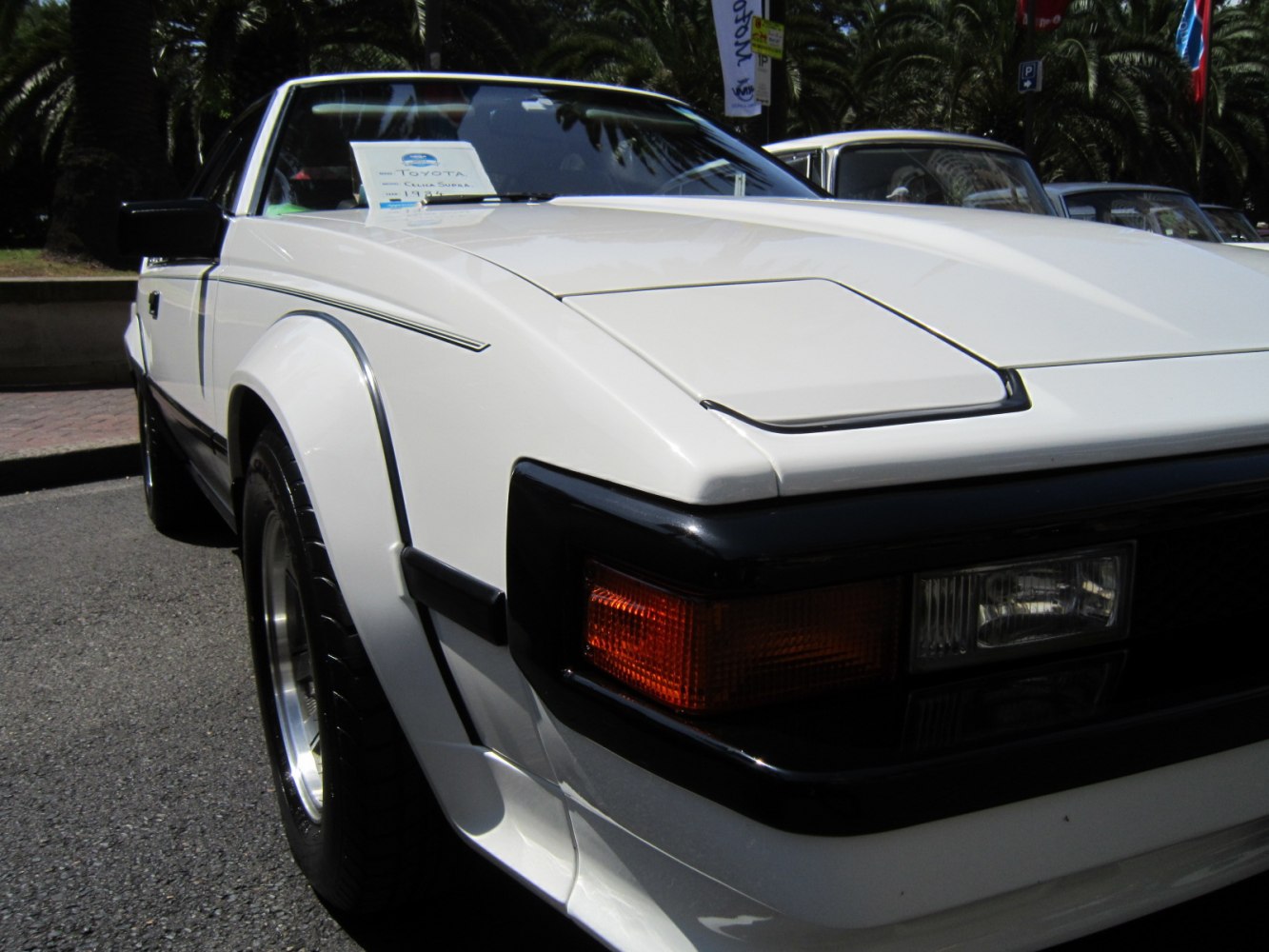 Close-up of front left corner with pop-up headlights and wide fender.