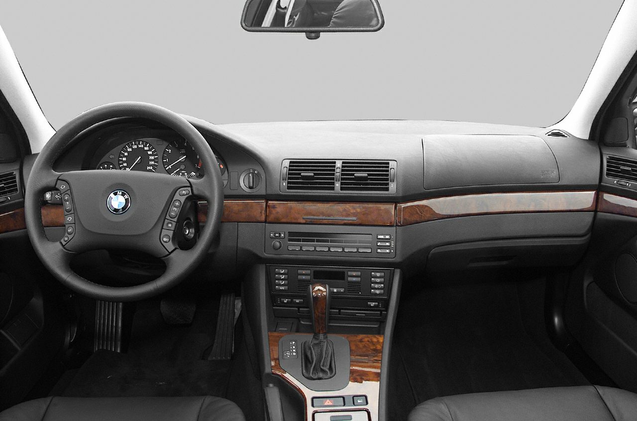Wood-trimmed dashboard and steering wheel with control buttons.
