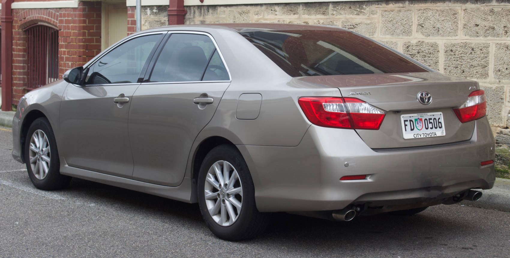 Rear side view of mid-size sedan with dual exhaust and clear taillights.