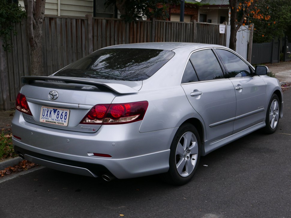 Silver sedan rear with spoiler, tail lights, alloy wheels