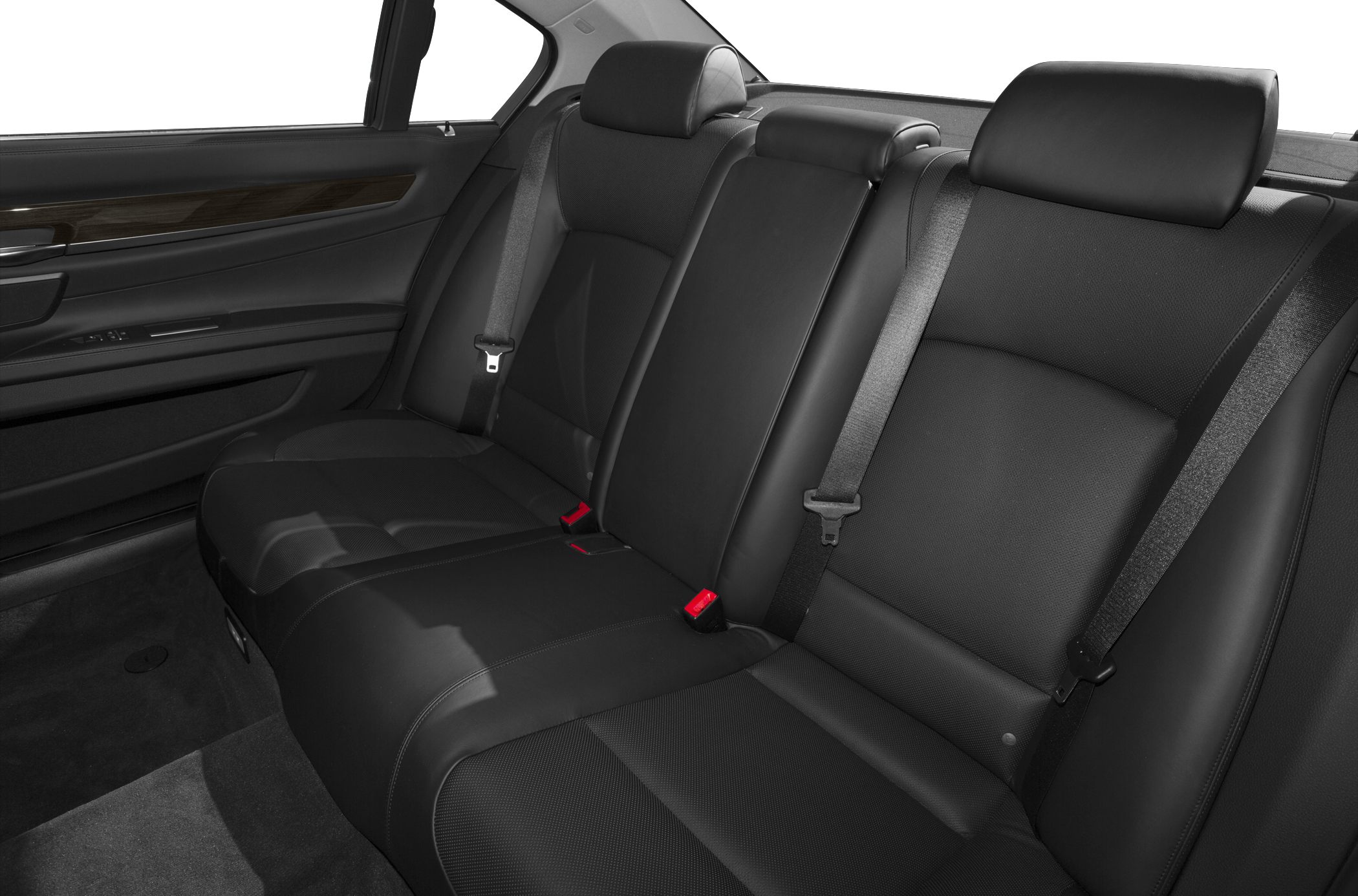 Luxurious black leather rear seats with wood trim and seat belts.