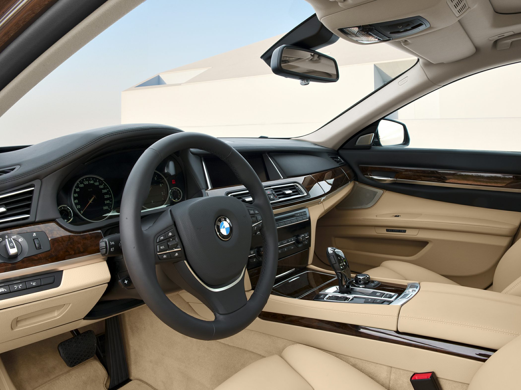 Luxury BMW interior with dashboard, steering wheel, and wood trim details