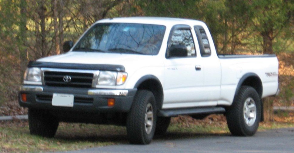 Front and side view of a white pickup truck with off-road tires.