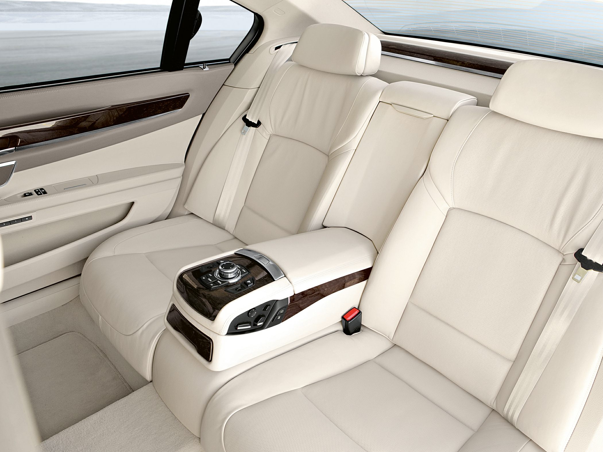 Beige leather rear seats with central control console and wood trim