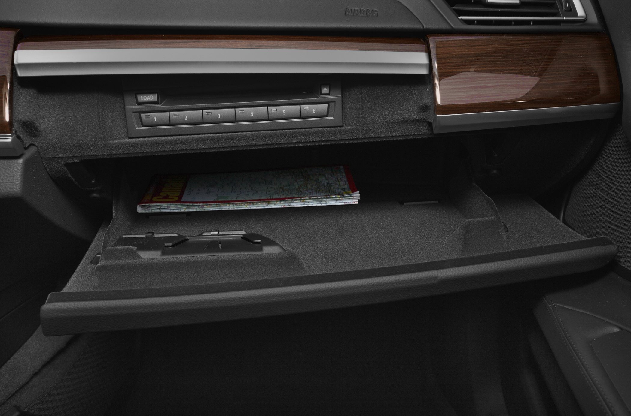 Open glove compartment and audio control buttons with wood trim interior
