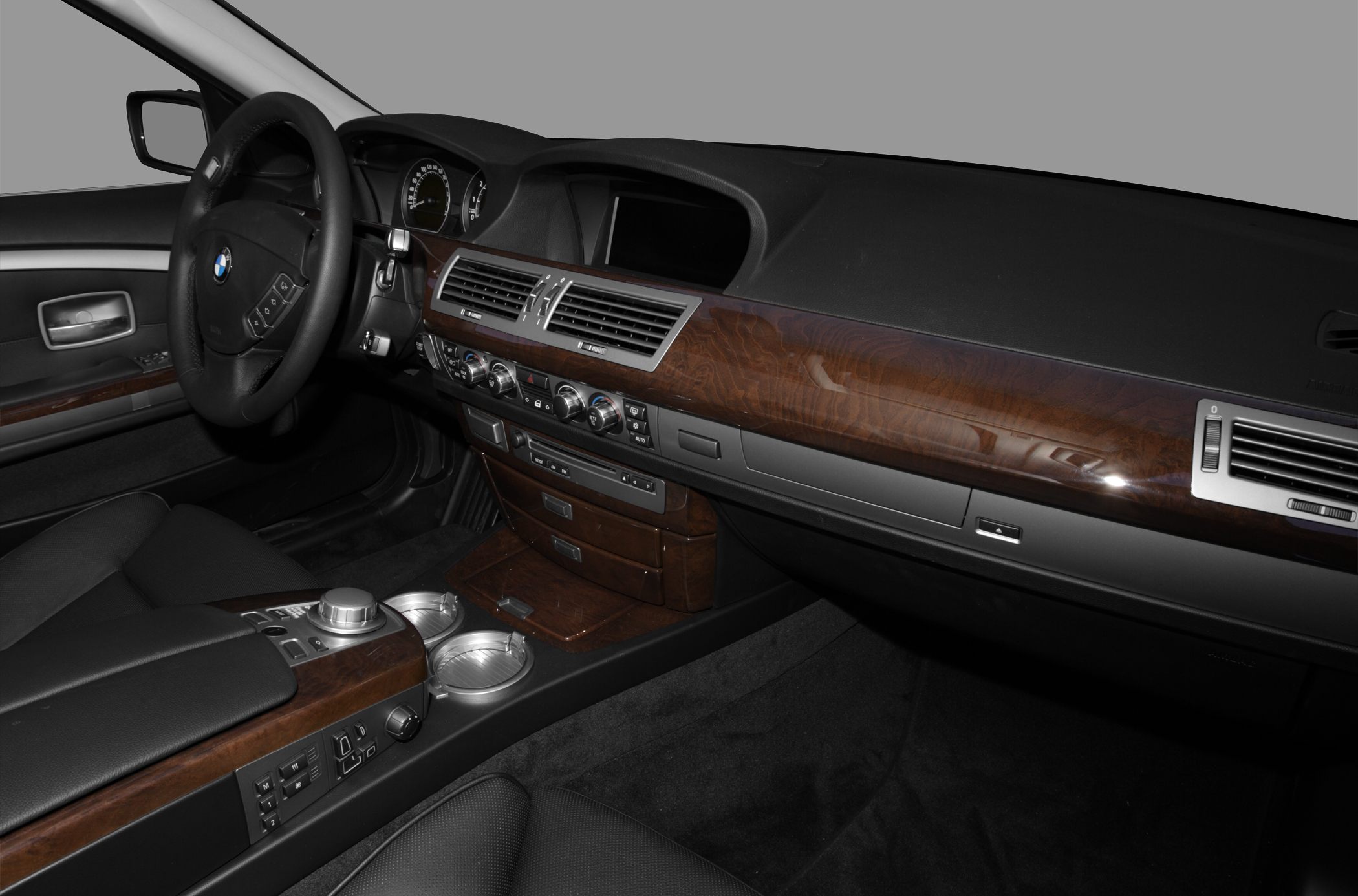 Luxury car interior with wood dashboard and multi-function steering wheel
