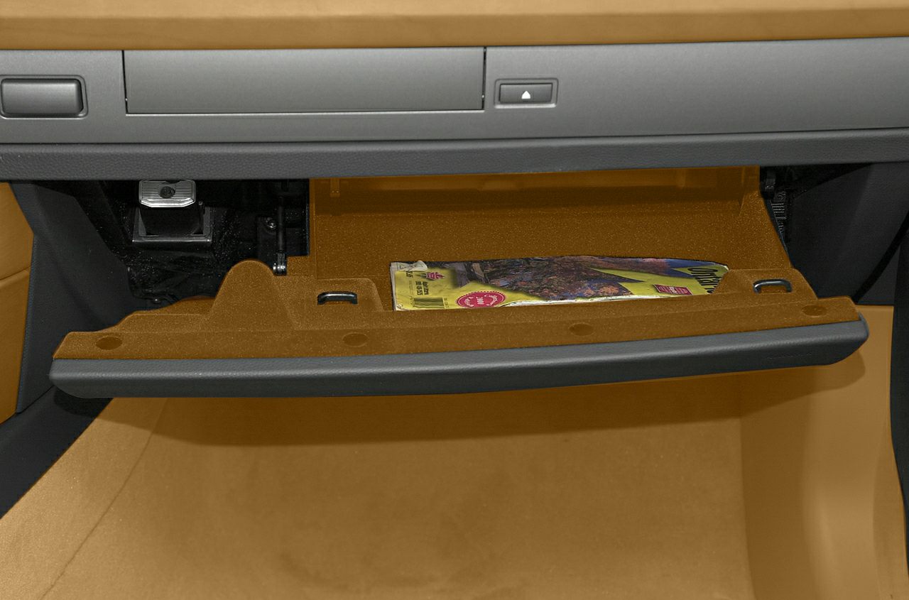 Open glove compartment showing storage space and items inside