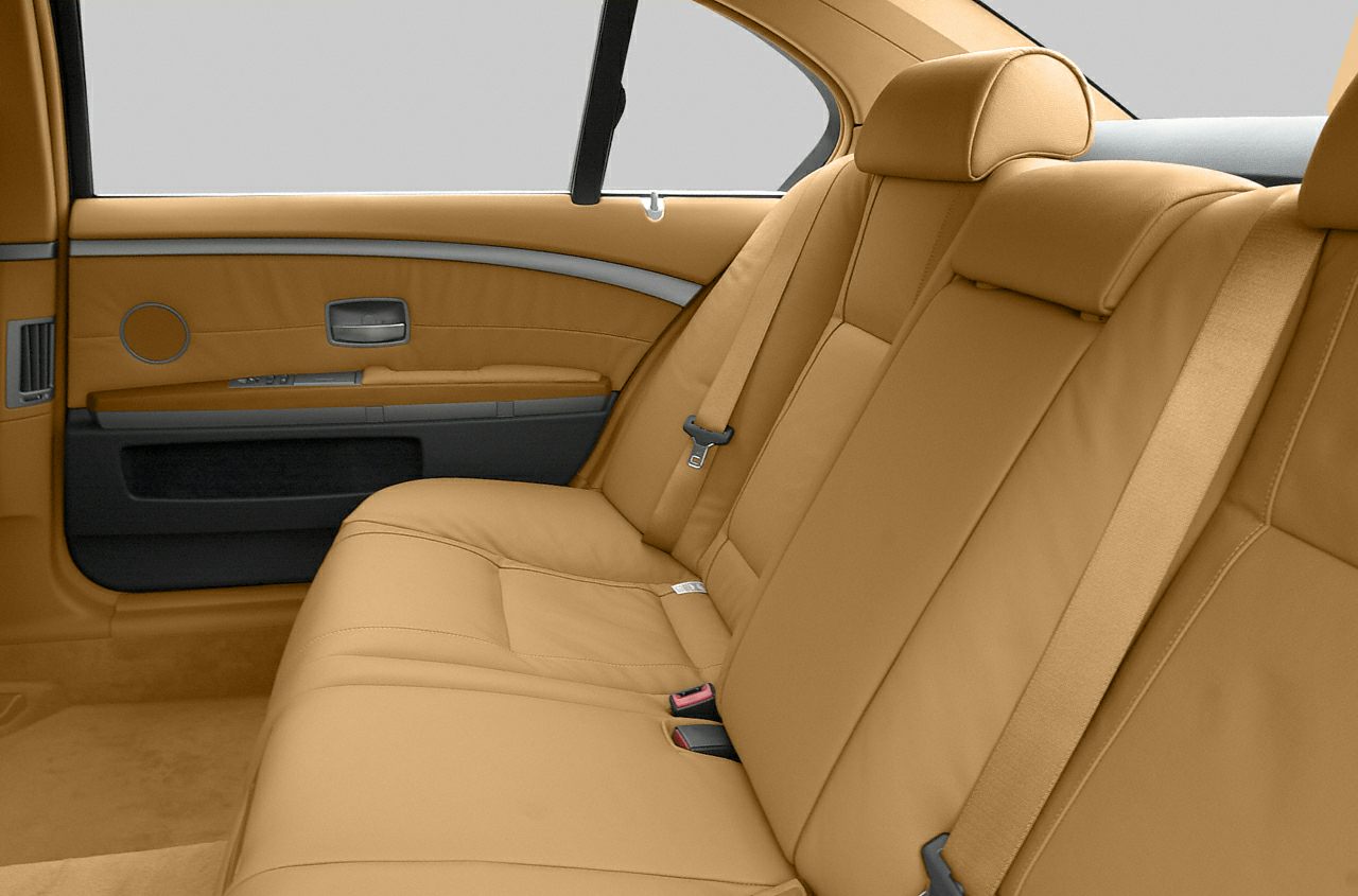 Tan leather rear seat interior with seat belts and window detail