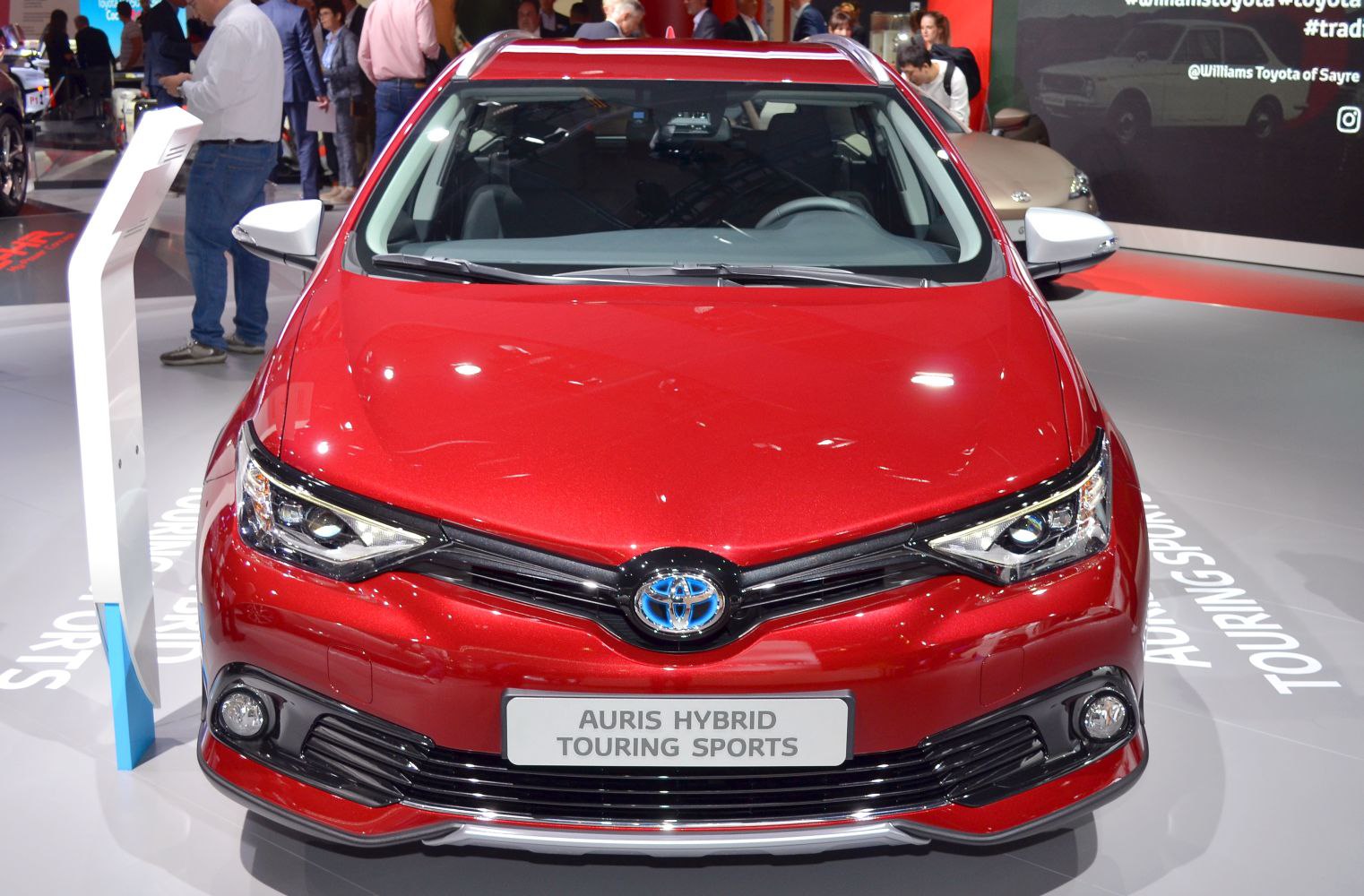 Red car front with hybrid badge and dynamic headlights