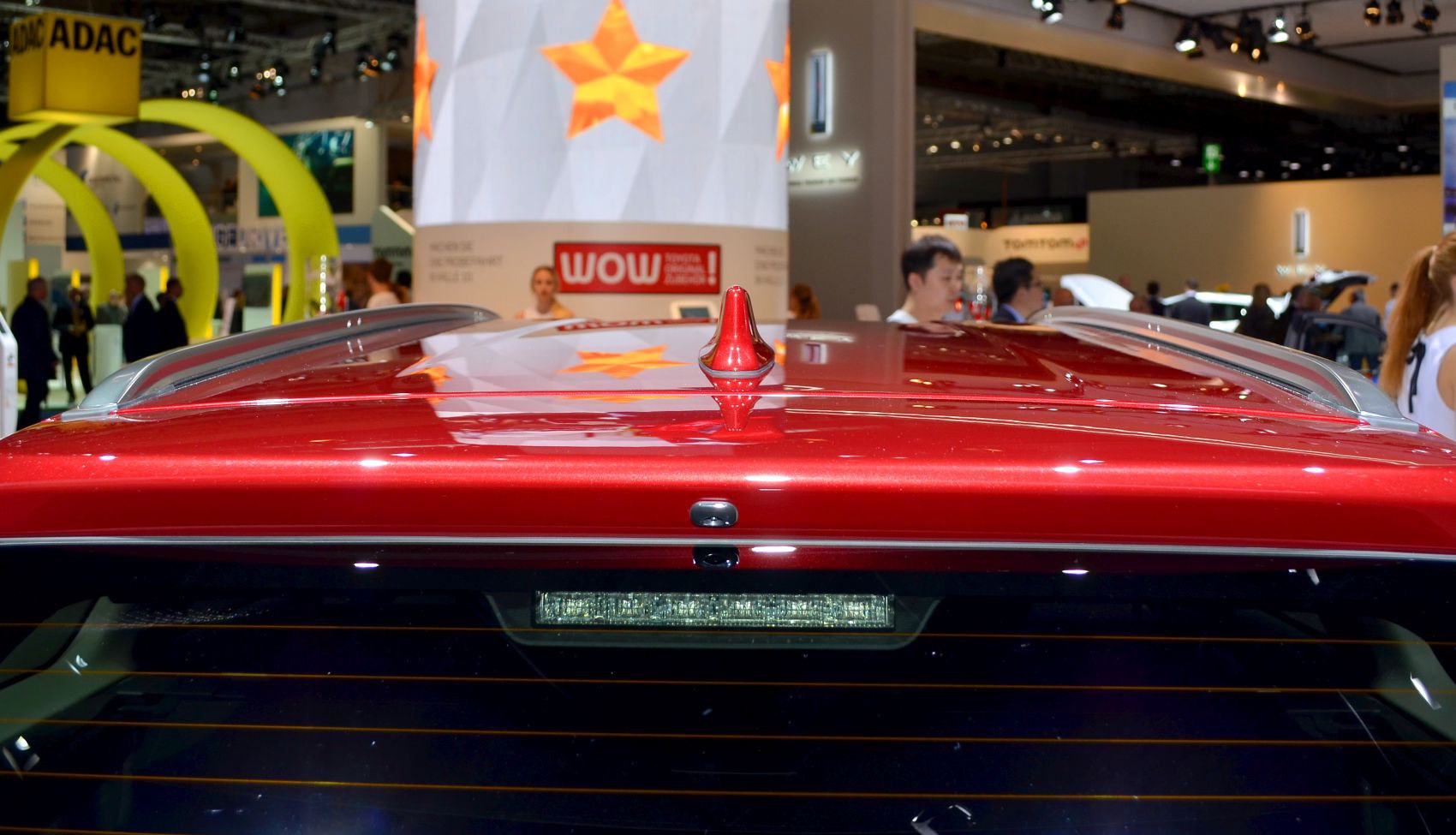 Shark fin antenna and silver roof rails on car roof with rear window light.