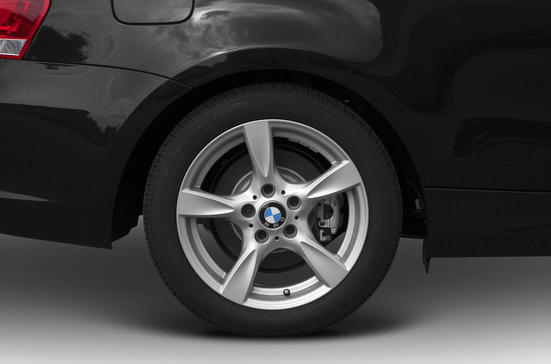 Silver five-spoke alloy wheel and black rear quarter panel