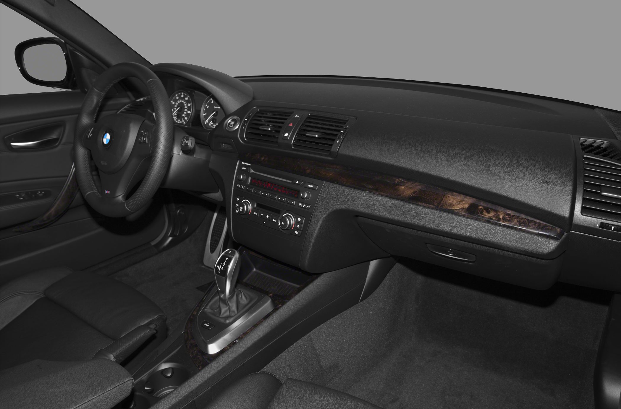 Dashboard with wood trim, leather seats, and automatic gear lever