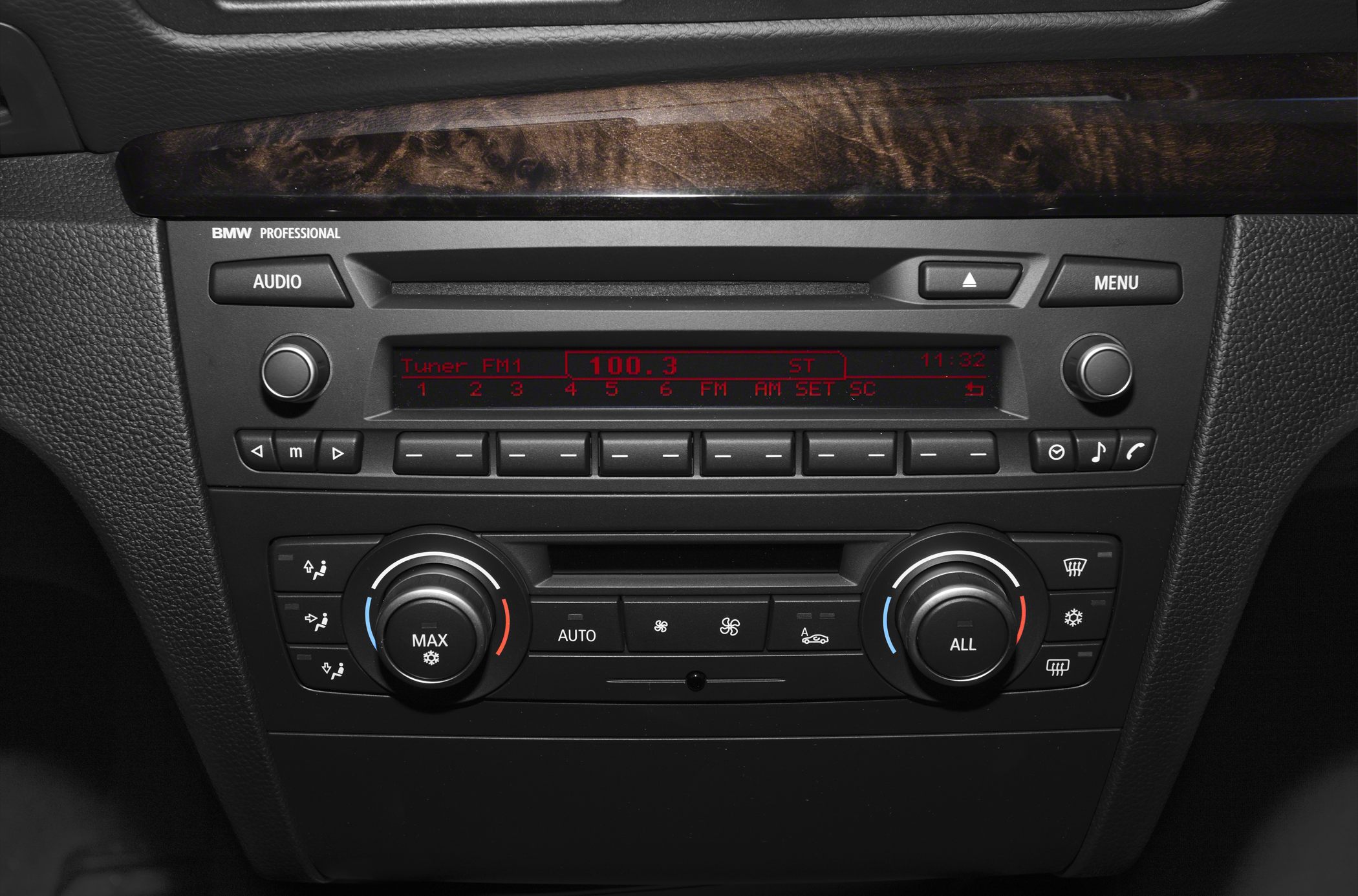 BMW radio display and dual-zone climate control knobs with wood trim