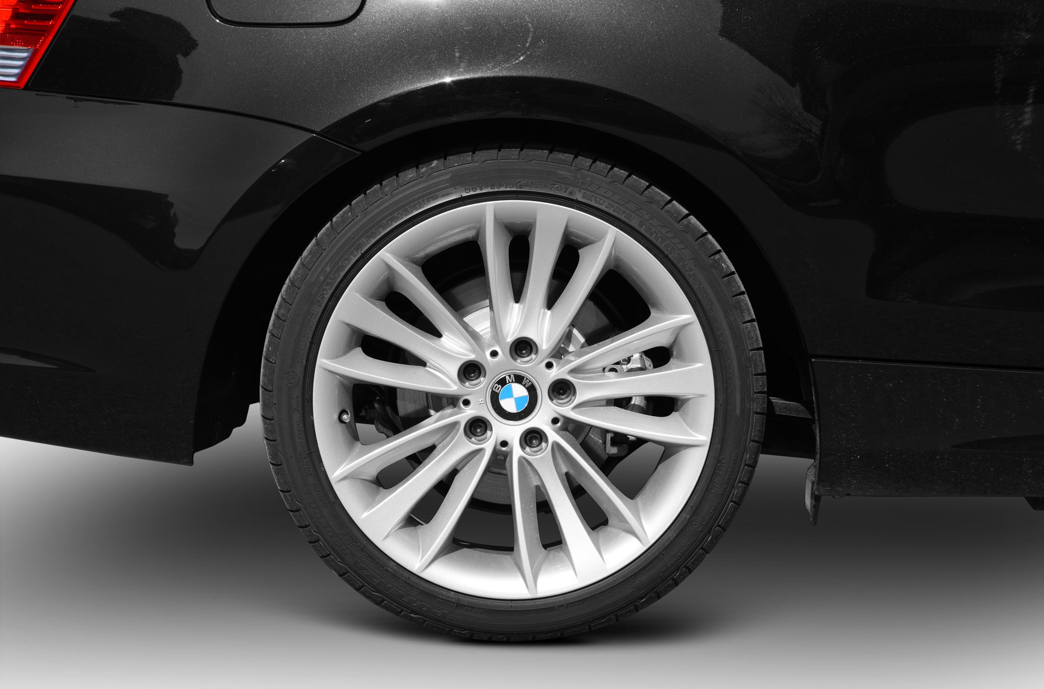 Silver multi-spoke alloy wheel on a black vehicle