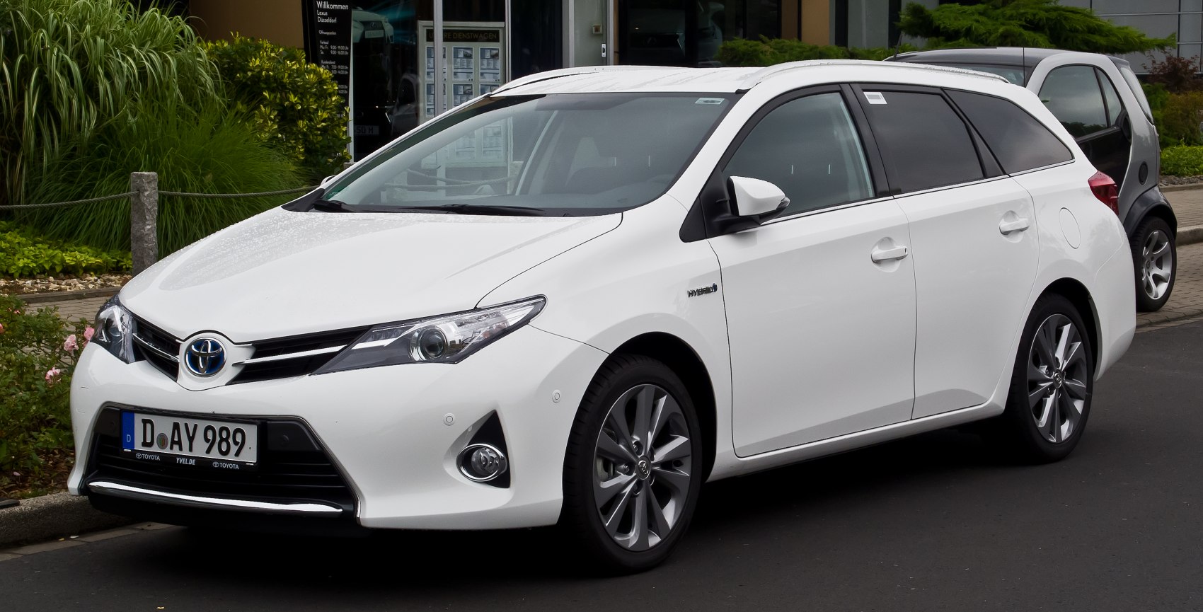 White hybrid wagon front three-quarter view with alloy wheels and headlamps