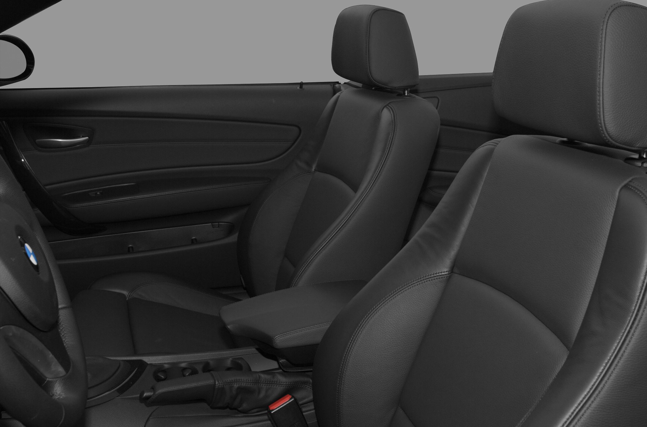Close-up of black leather front seats and driver's side door panel