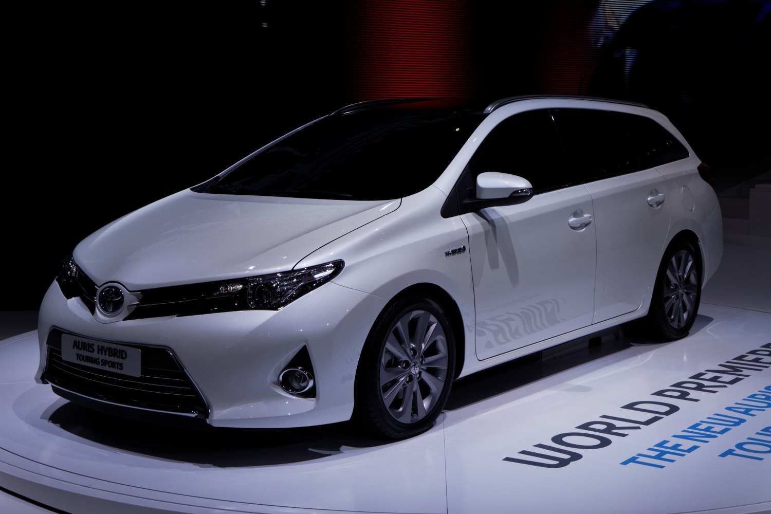 White hybrid station wagon with sleek front design and alloy wheels