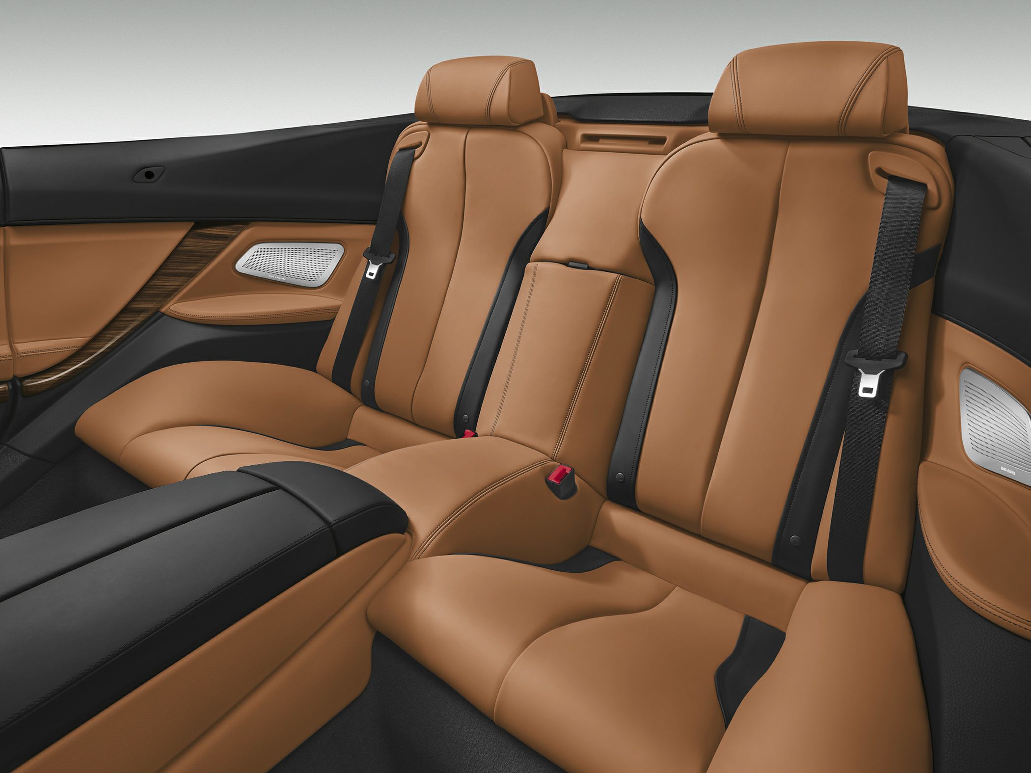 Luxurious brown leather rear seats with black accents and integrated seatbelts.