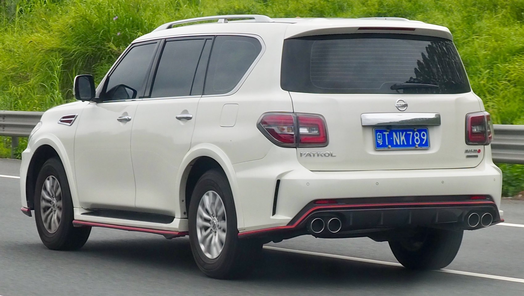 White SUV with quad exhaust, tinted rear windows, rear-side angle view