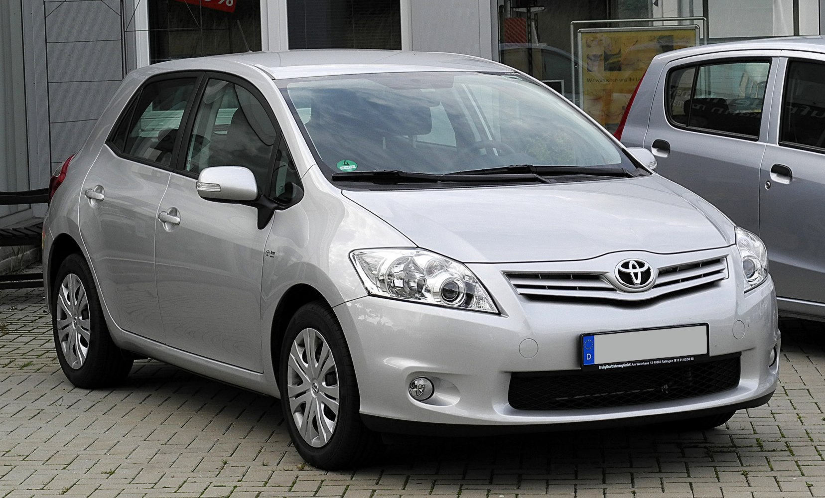 Front and side view of hatchback with distinct headlights and grille