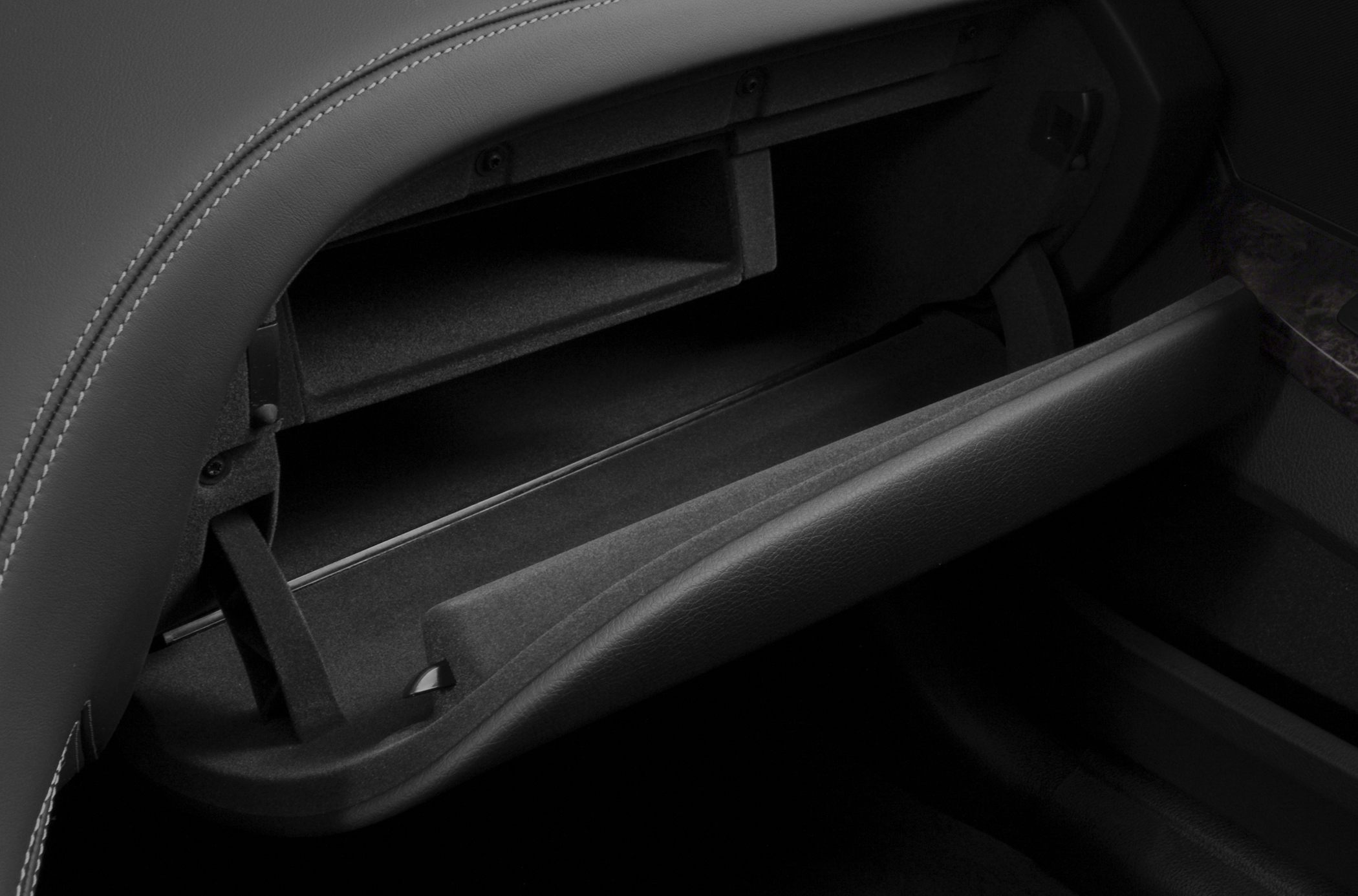 Open glove compartment with structured interior storage shelf.