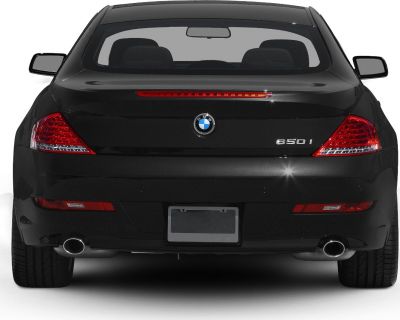 Rear view of black luxury coupe with dual exhaust and distinct taillights
