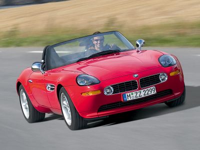 Red convertible roadster with chrome mirrors and distinctive front grille