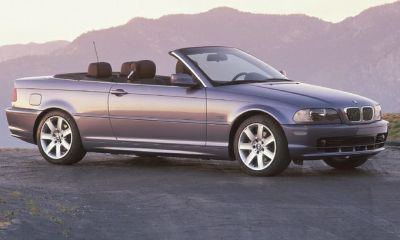 Side profile of a convertible with retractable roof and alloy wheels.