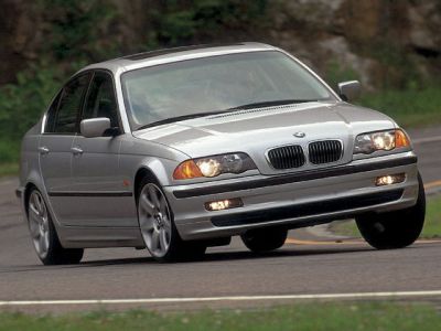 Silver sedan front view turning on road with classic grille and headlights